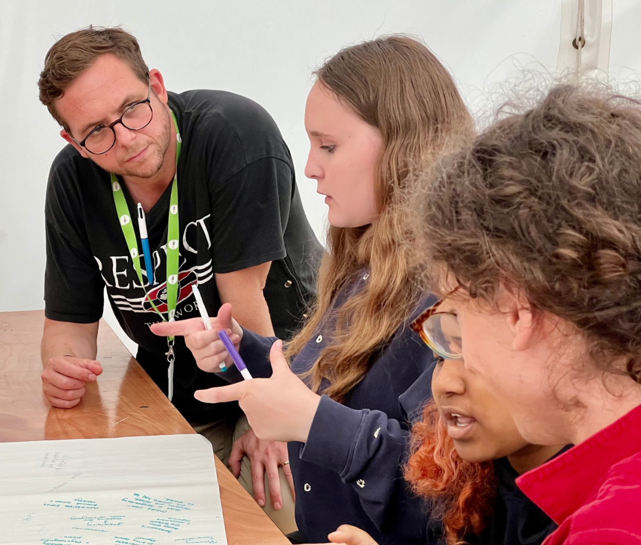 Youth worker listening to a table of young people