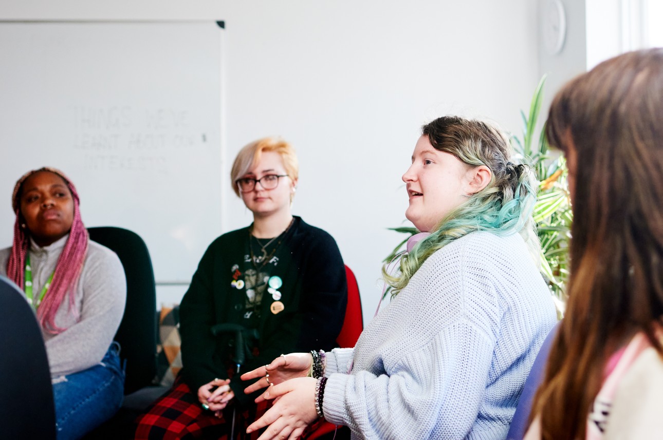 Young people sat in a circle talking