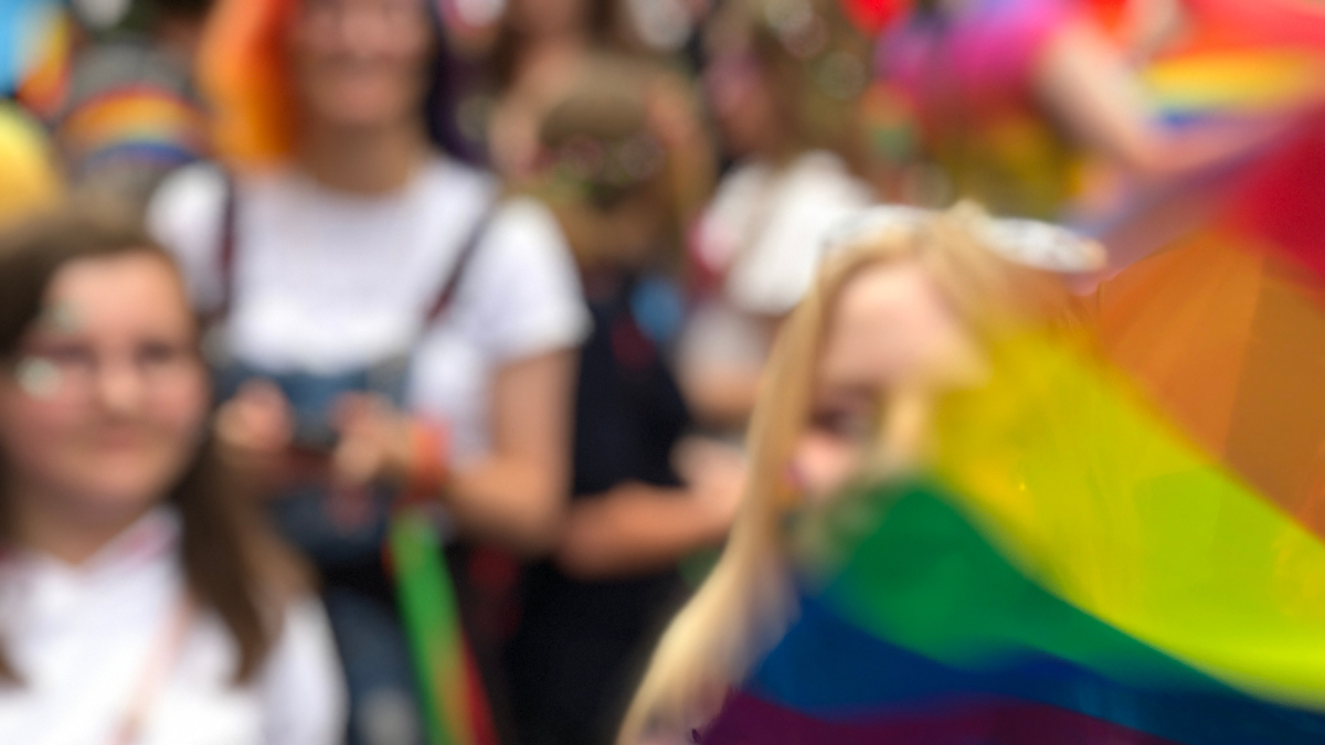 out of focus image of crowd with Pride flag