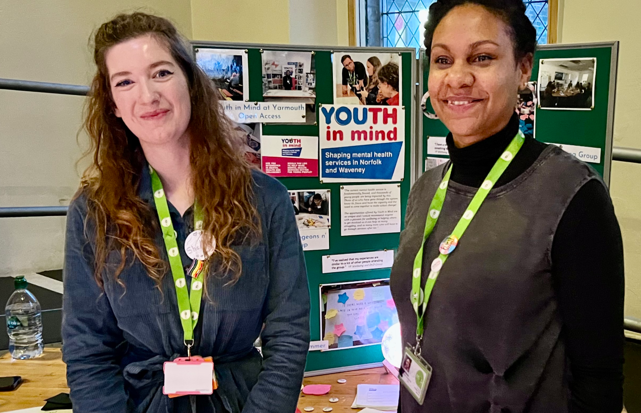 Two youth workers in front of Youth In Mind stand