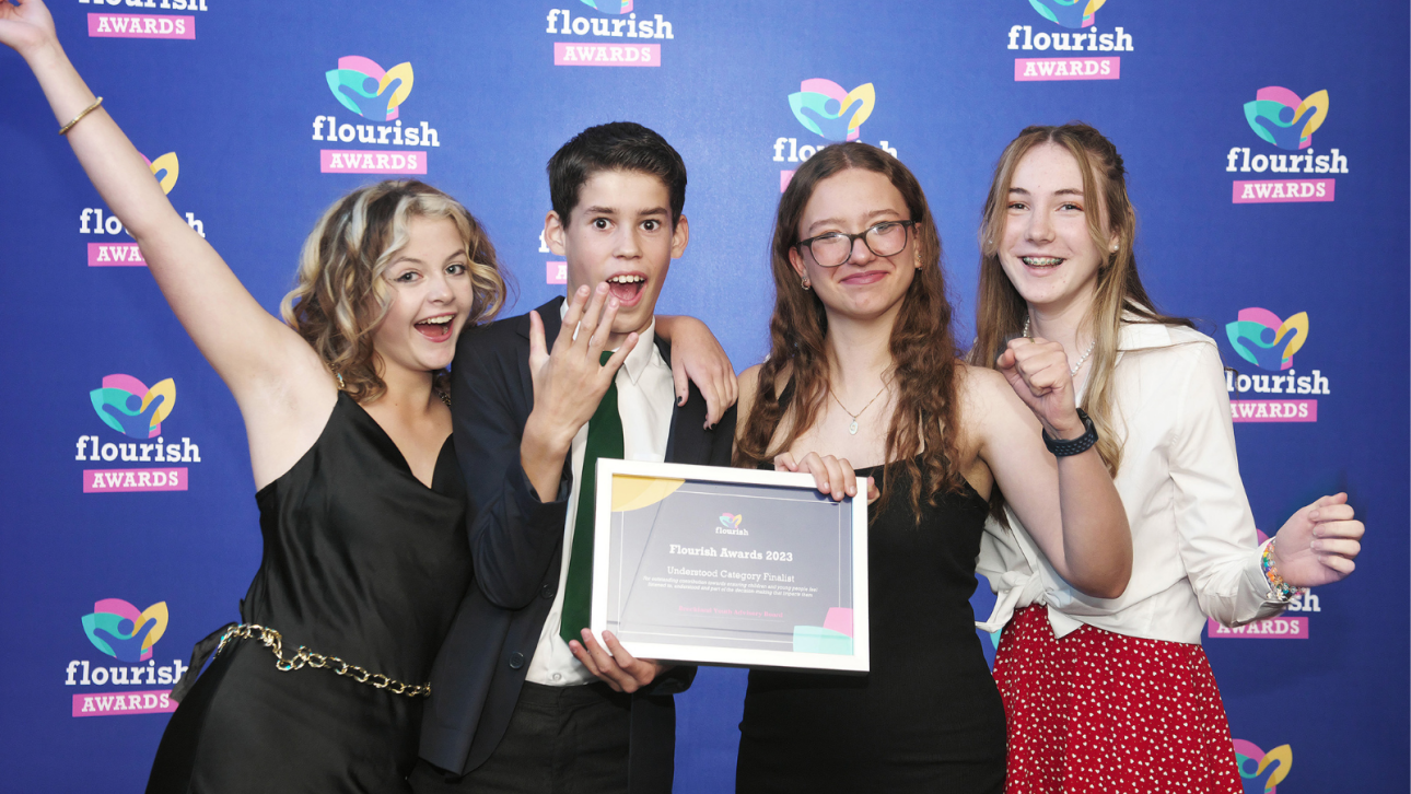 Four young people holding their flourish award celebrating