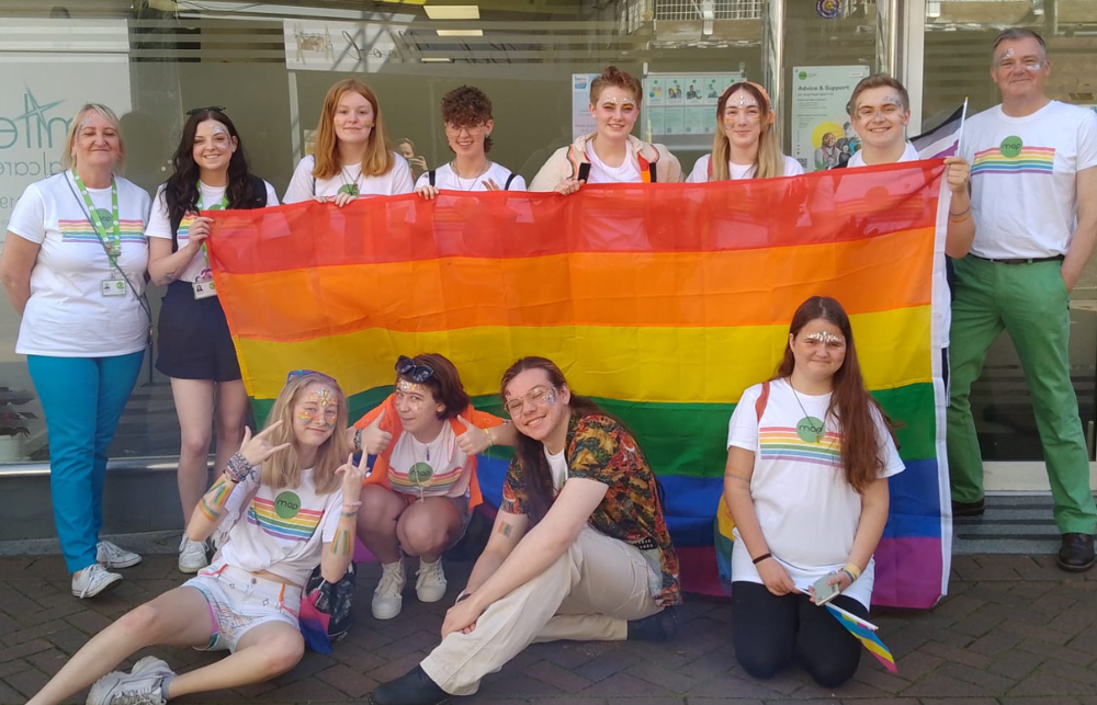 Young people in MAP tshirts holding a pride flag