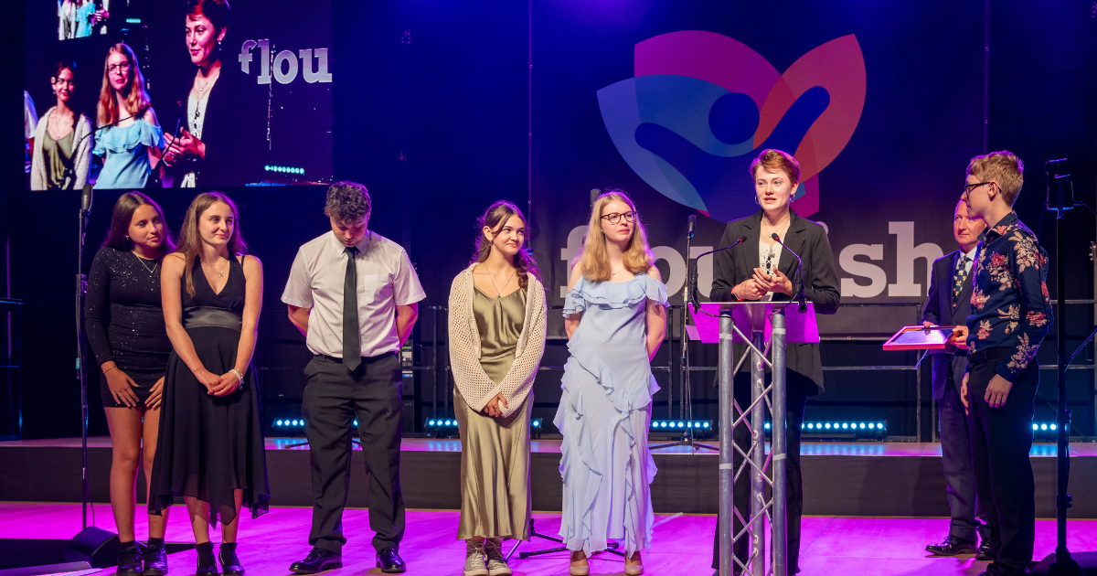Young people accepting a FLOURISH award on stage