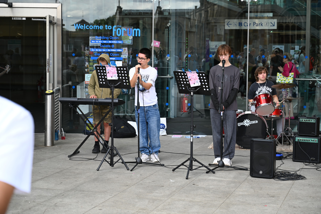 Four young people playing in a band outside the forum in norwich