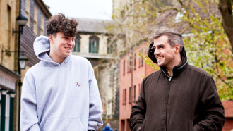 A youth worker walking outside with a young person
