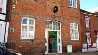 Large brick building with MAP sign above an open door