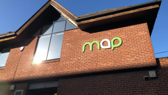 Outside of the risebrow centre. There's a large 'MAP' sign on the outside of the building next to a large window