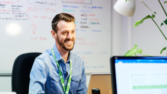 Mental health worker looking across a desk smiling