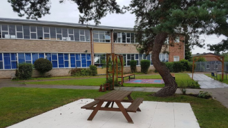 Picture of the outside of the Charles Burrell Centre, with a bench in the foreground
