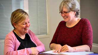 Two members of the core services team, stood around a table