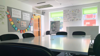 Large white table with colourful banners and green blinds in the background