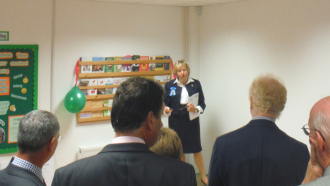 A crowd of people stood around Lady Dannatt giving a speech in the Great Yarmouth drop-in