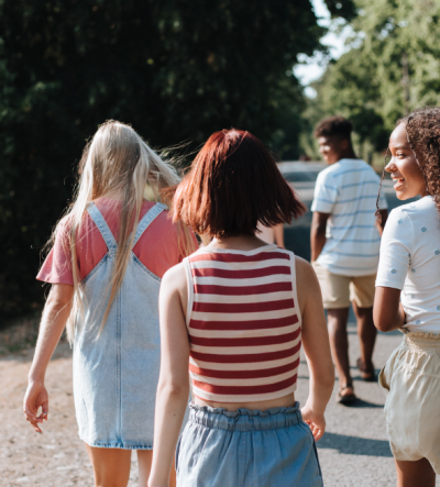 A group of young people in summer walking away from the camera