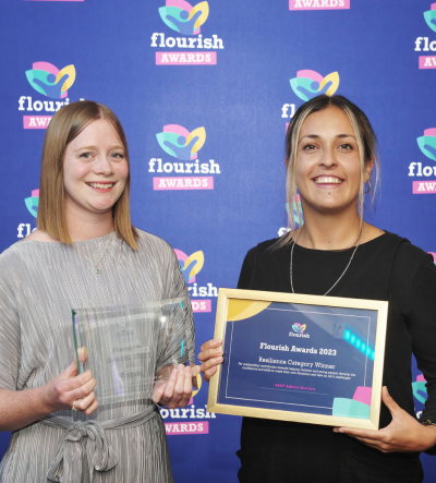 Two advice workers holding their flourish award