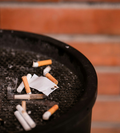 An ashtray bin against a brick wall