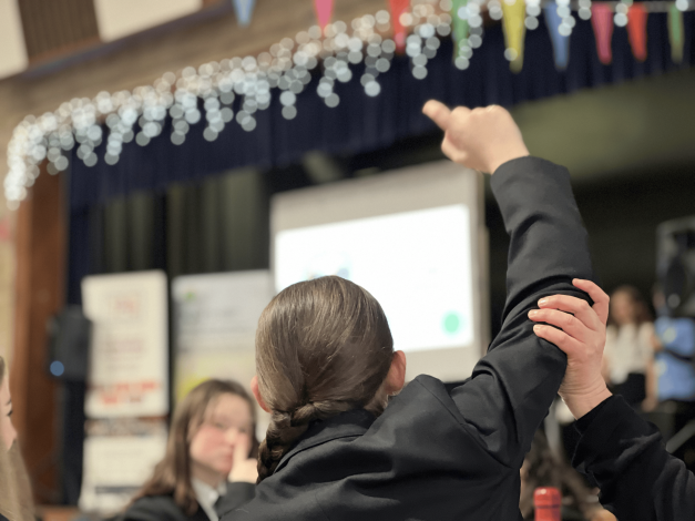 A young person raising their hand