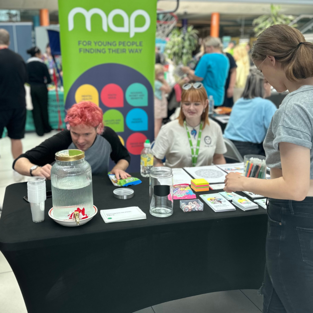 Young people and youth workers speaking at a MAP stall at Positive Minds