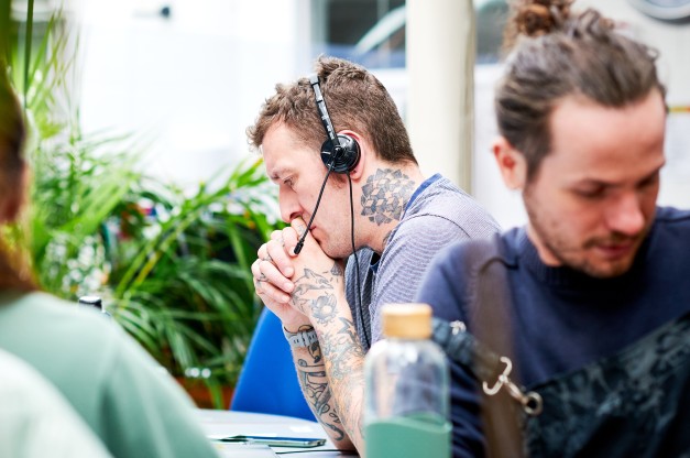 An advice worker listening to a call on a headset