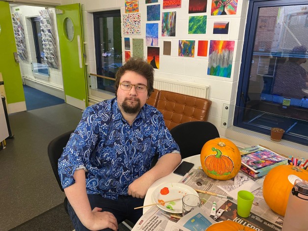 Young person at the Risebrow Centre sat with their freshly painted halloween pumpkins
