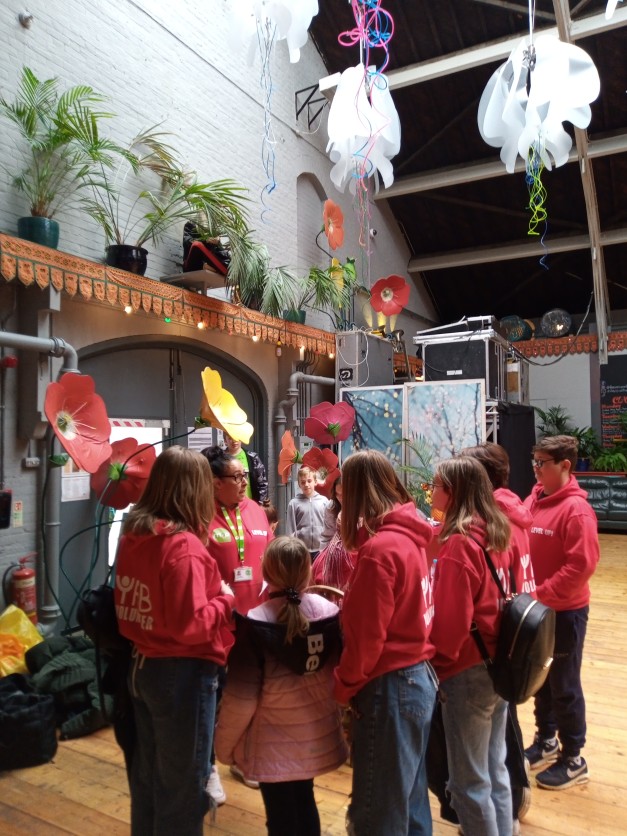 Group of young people in red hoodies talking to a youth worker