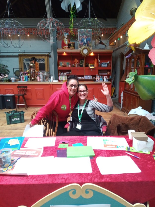 Two youth workers waving at the camera