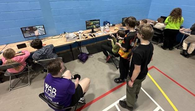 Young people playing multi tap console games around a table