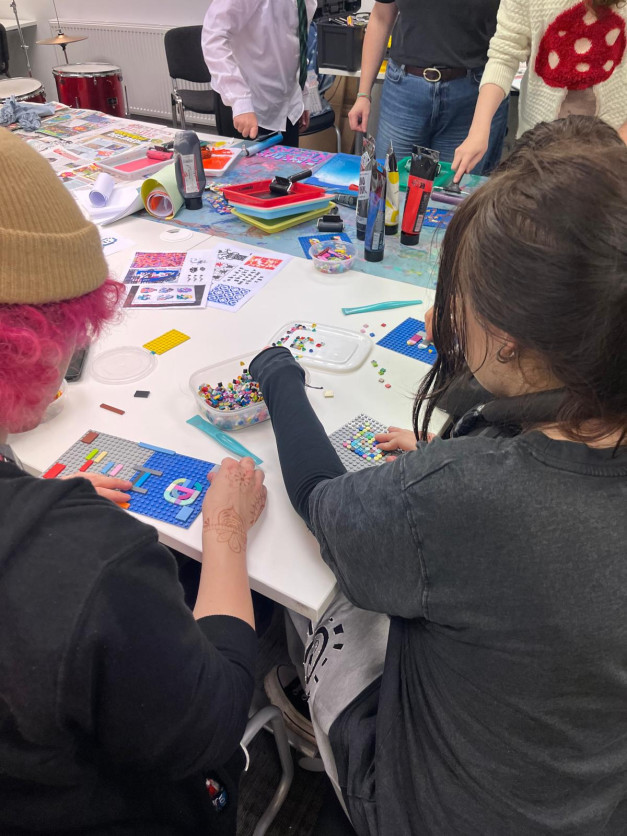 A group of young people putting lego pieces together in order to create lego print-making tools