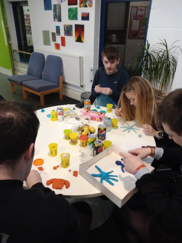 Young people sat round a table doing arts and crafts