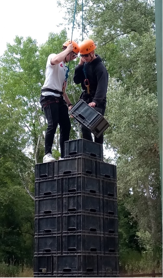Young people balancing on a tower of crates