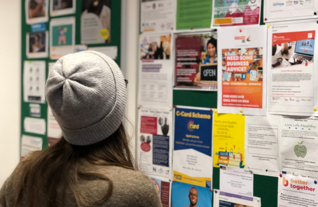 A young person looking at a noticeboard