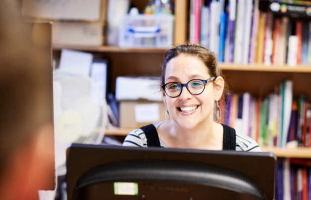Staff member sat at their desk in front of a bookcase