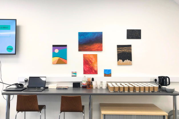 Colourful canvases painted by young people on a white wall