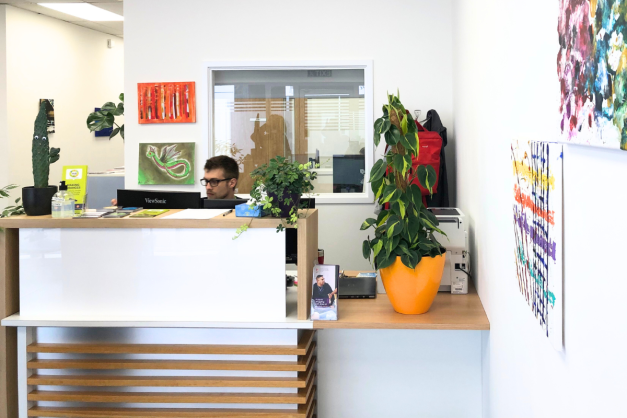 The reception desk at MAP's King's Lynn building surrounded by colourful art and plants